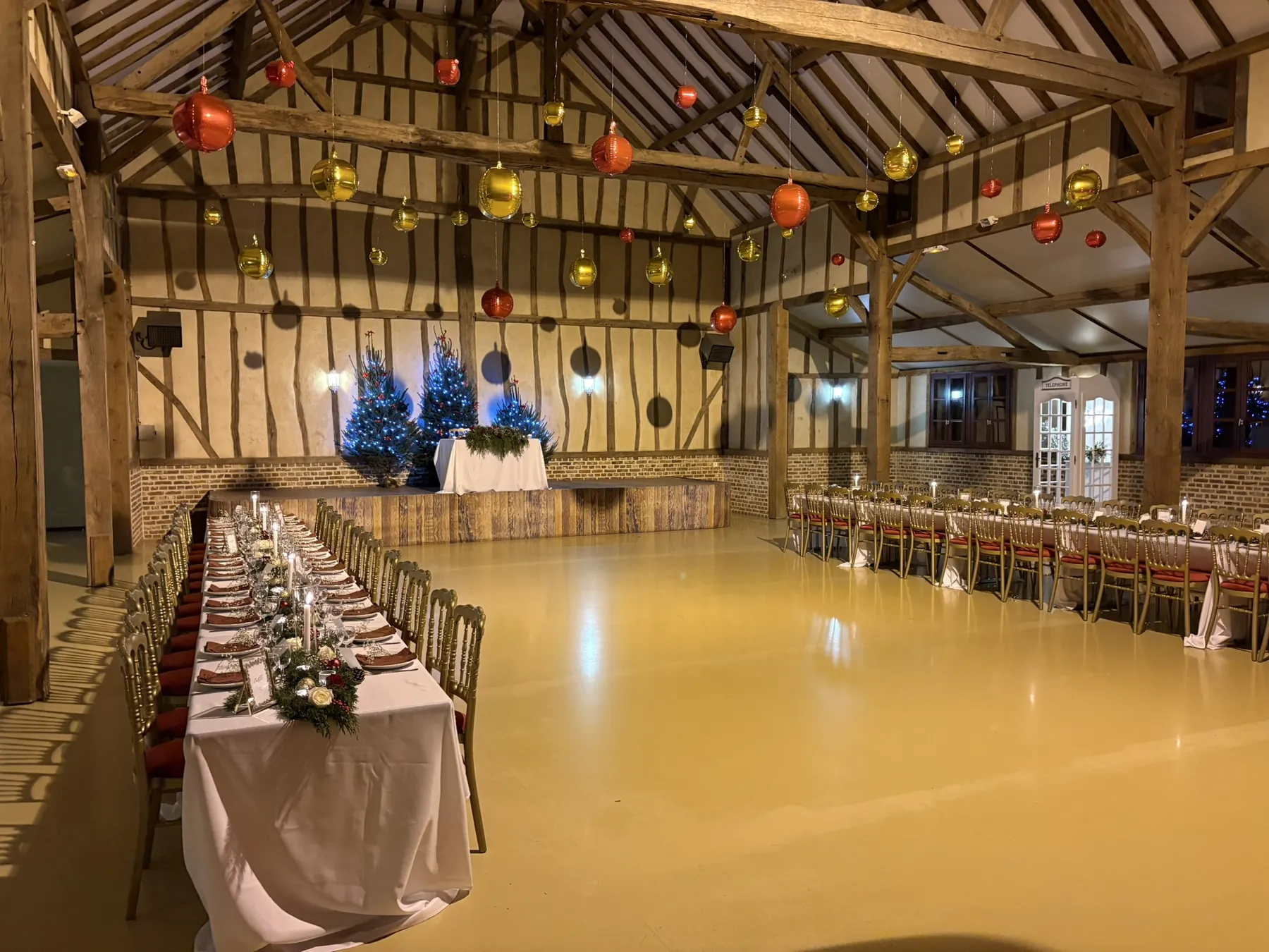Grange décorée pour un mariage d'hiver, longue table dressée et boules suspendues