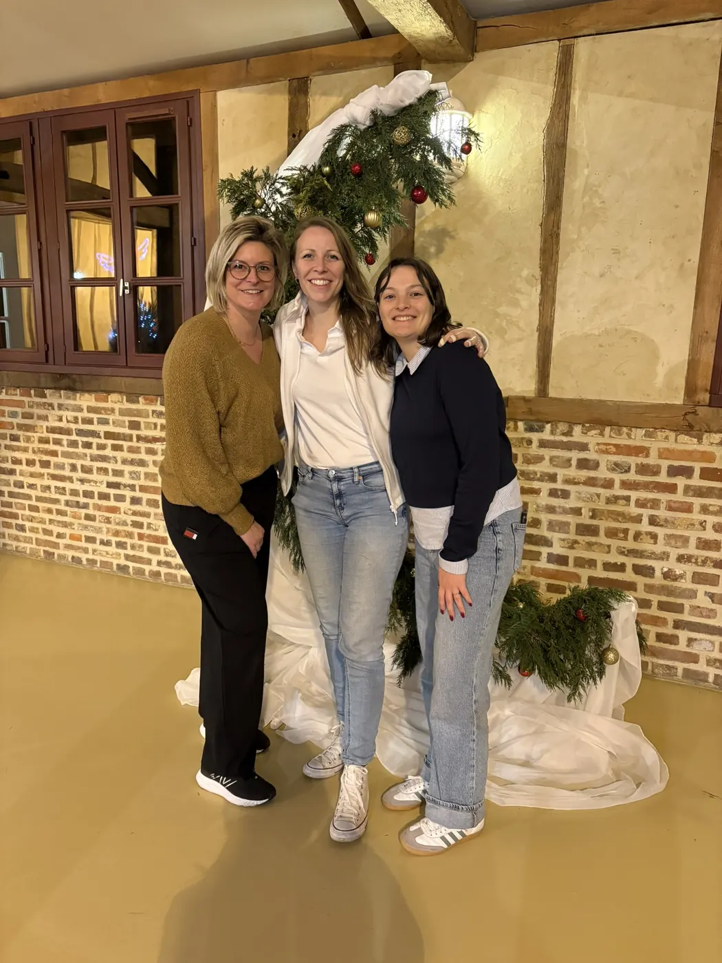 Chloé et son équipe devant l'arche d'une grange décorée pour un mariage d'hiver