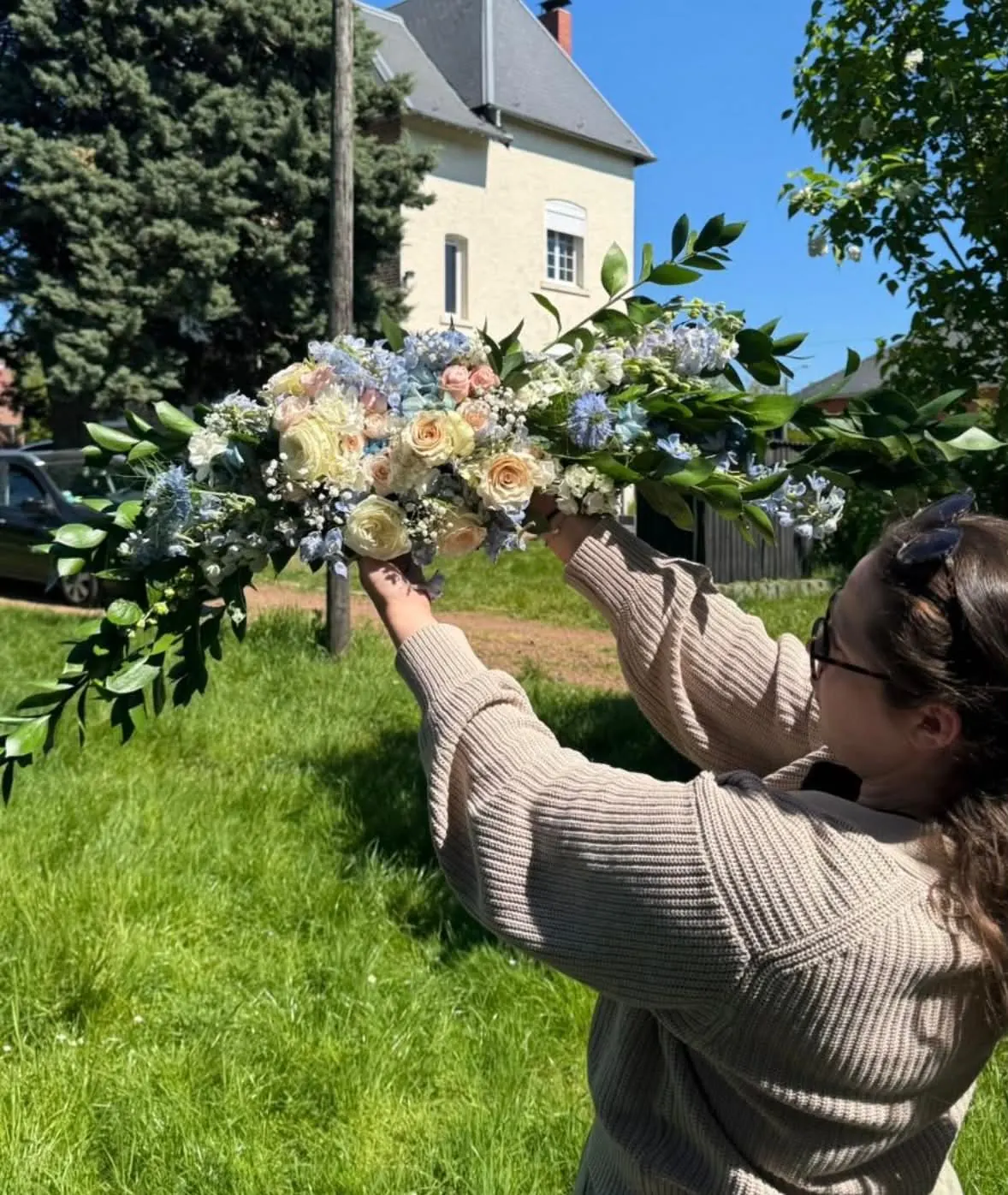 Chloé installe une arche fleurie dans un jardin