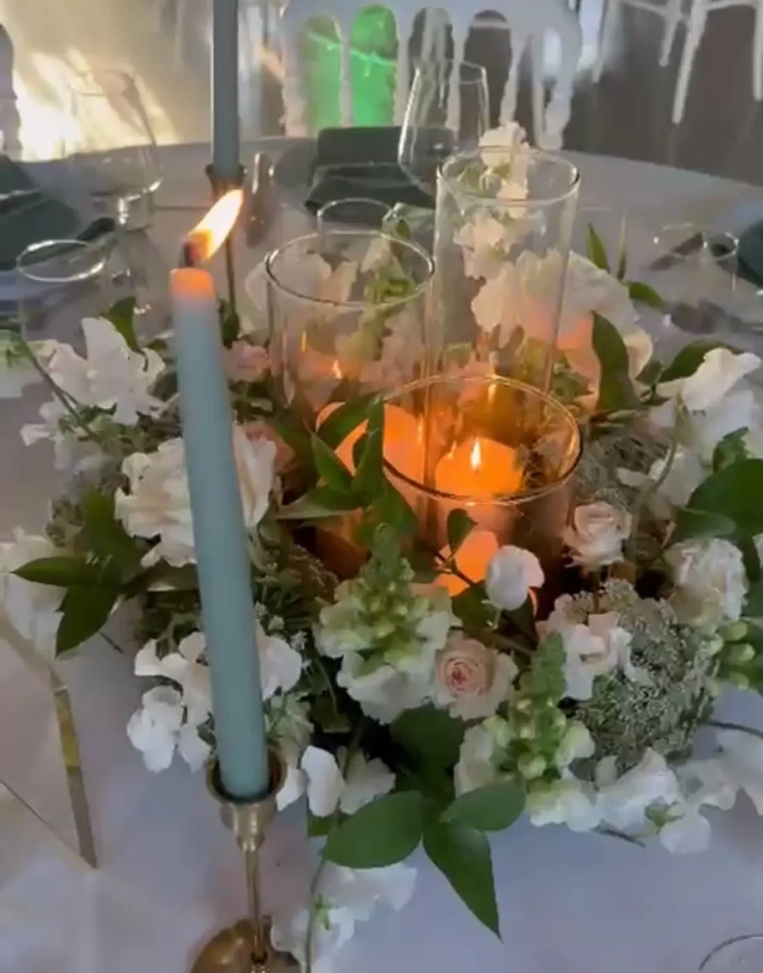 Centre de table avec bougie, roses pâles et feuillage, création Evidence & Emotions
