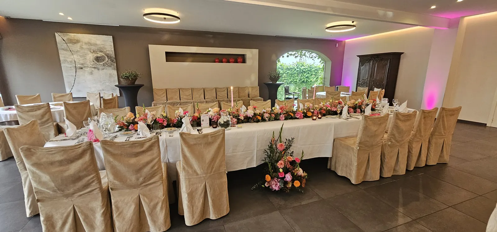 La salle de réception de Rachel et Arnaud, tables dressées avec bouquets colorés et bougies roses